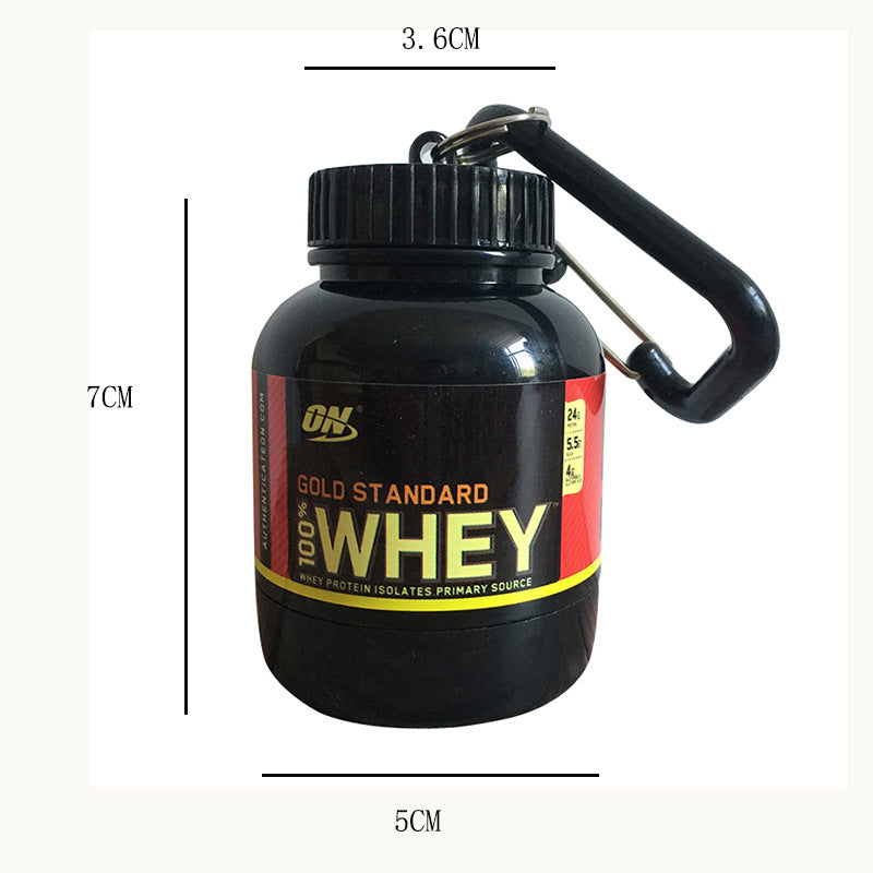 Black container with 'Gold Standard Whey' label and carabiner, shown with measurements.