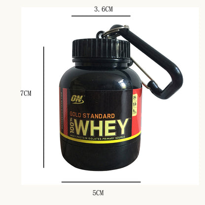 Black container with 'Gold Standard Whey' label and carabiner, shown with measurements.
